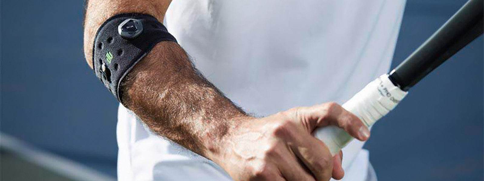 The Sports Elbow Strap prevents a tennis arm and supports your tennis game Tennis player with an elbow bandage has tennis racket in hand