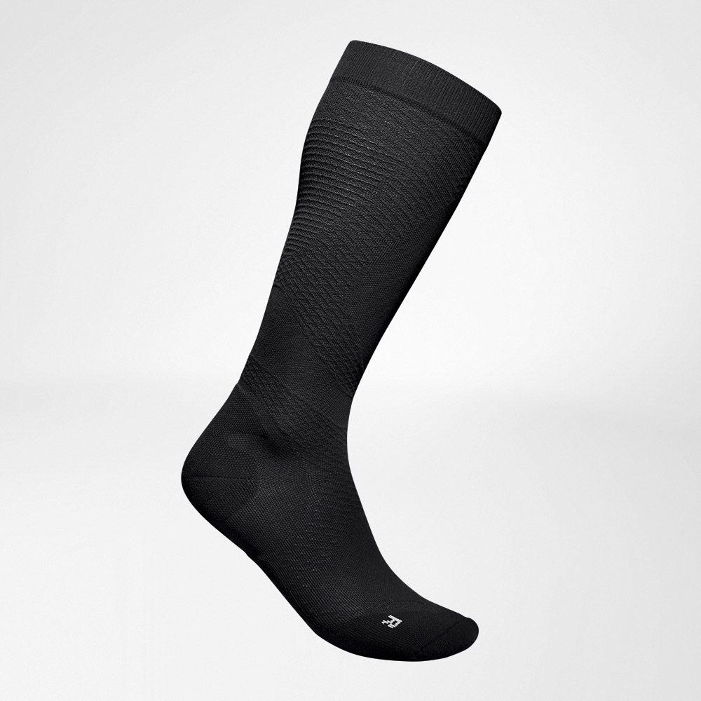 Lateral complete view of the black, airy, knitted compression socks to run