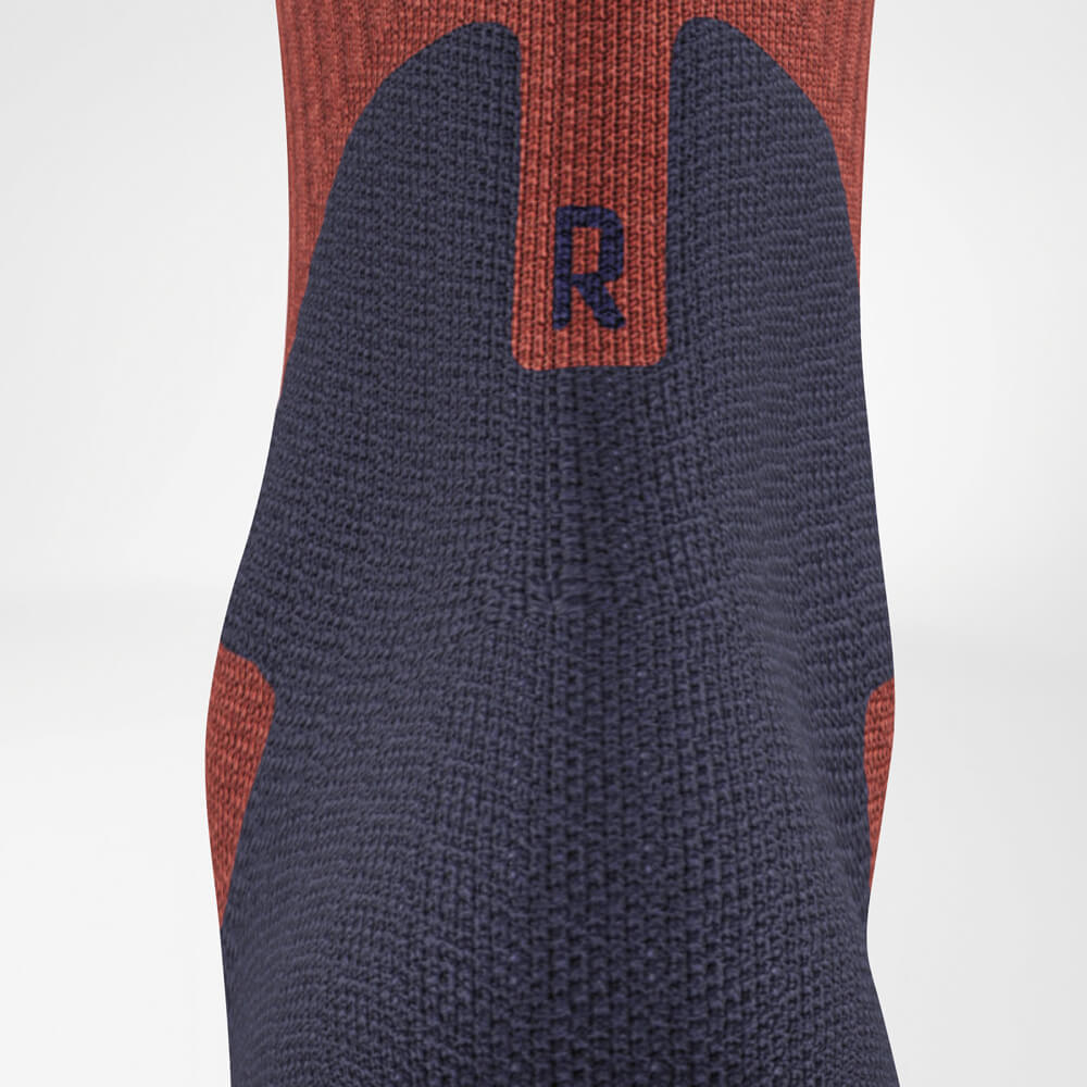 Close-up view of the Merino Outdoor Socks from the back. The seamless design and targeted Achilles padding provide comfort and protection for extended outdoor use.