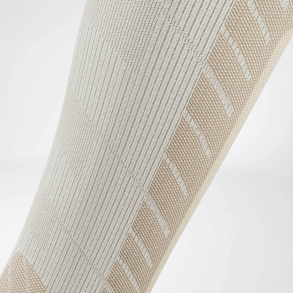 Detailed view of the calf compression zone of the beige sports socks for skiing with merino wool