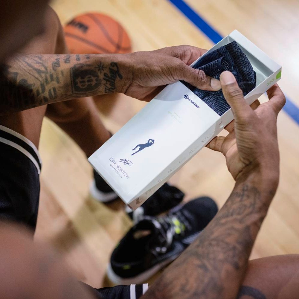 An athlete opens a box containing the Dirk Nowitzki Special Edition ankle support.