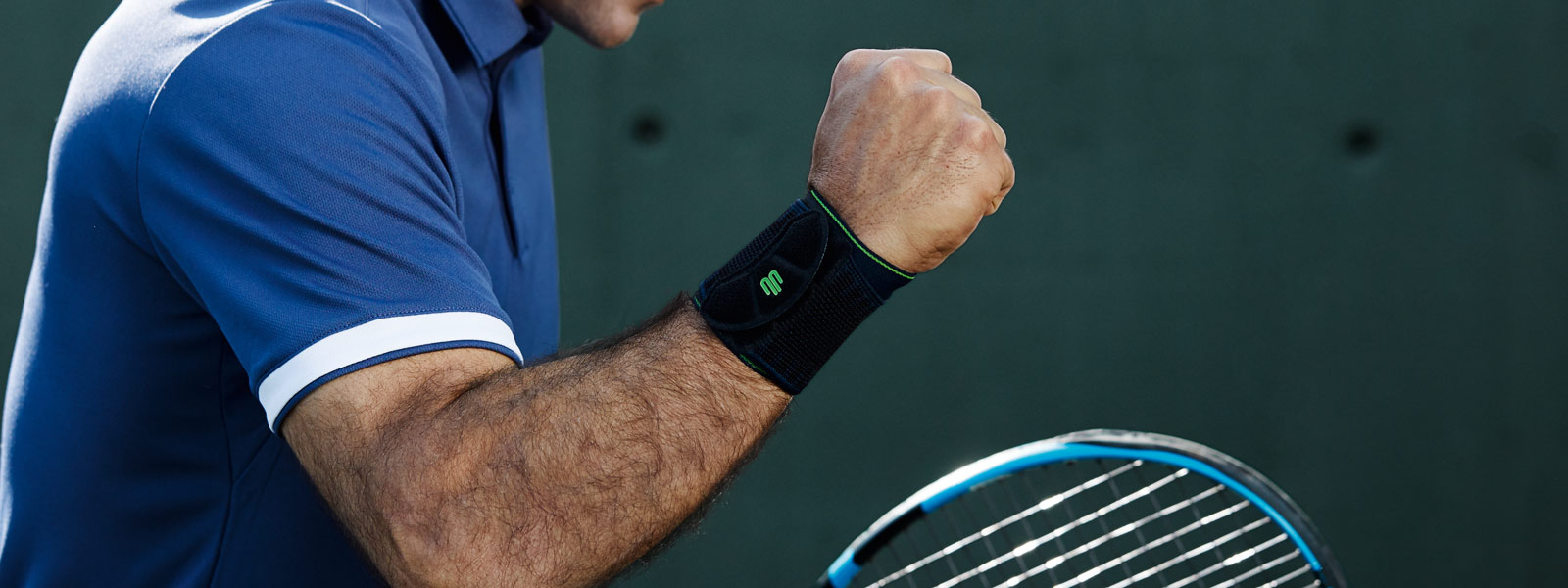 More power for the wrists with Sports Wrist Support Tennis player with a black wrist bandage balls the fist