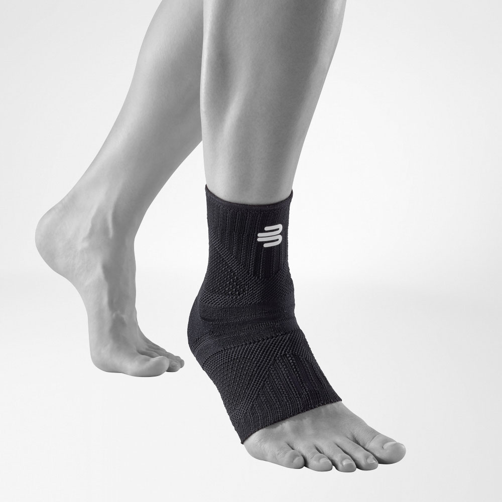 Front complete view of the allblack-colored Ankle Support Dynamic on the stylized gray leg