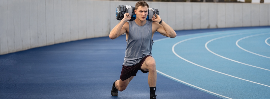 Training with an ankle bandage Runner with compression Ankle Support trains with dumbbells