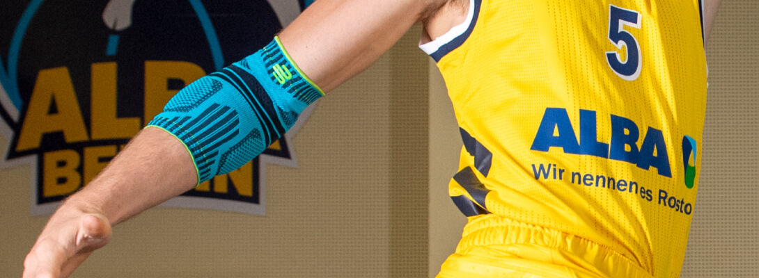 Ellenbogen bandage in basketball Basketball player with Alba Berlin jersey wears a sports bandage for the elbow