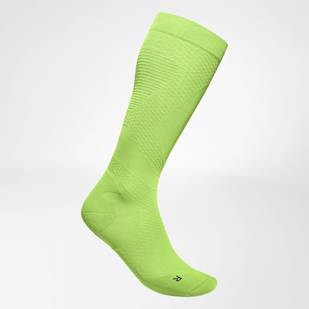 Lateral complete view of the green airy knitted compression socks to run