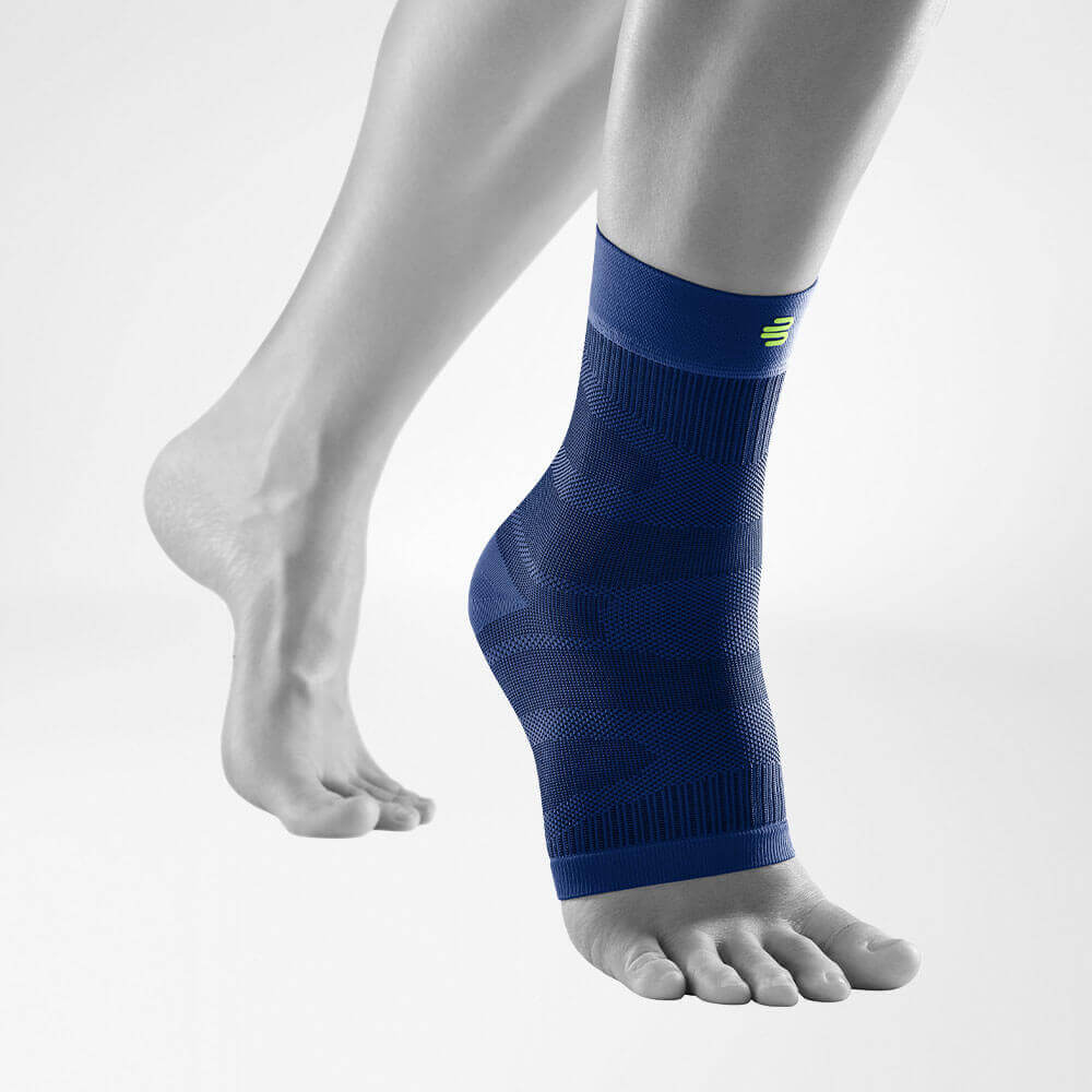Complete view of the dark blue compression Ankle Support on a stylized gray leg
