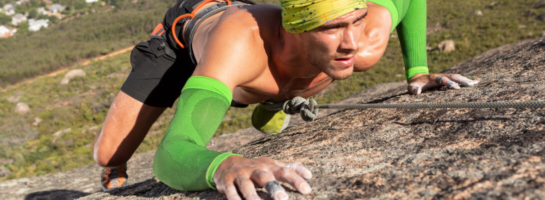 Arm Sleeve climbing The climber on the rock wears green compression Sleeves for the arm