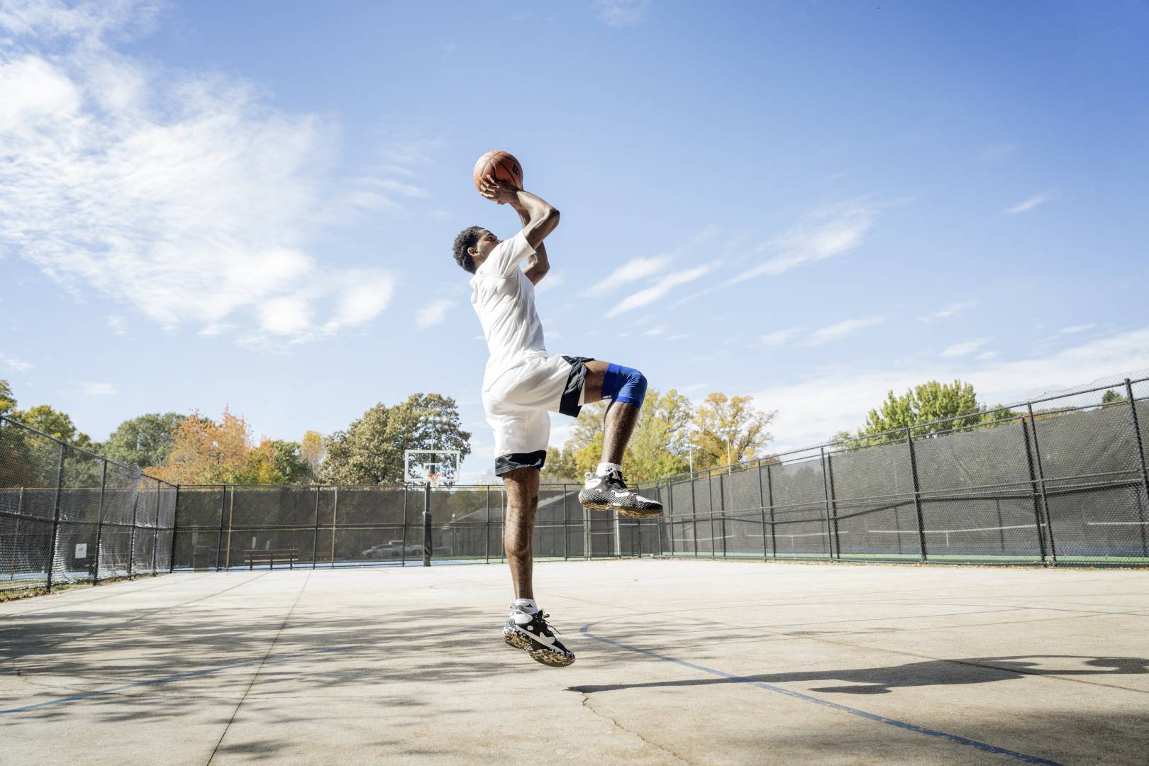 Crucial for every successful throw: determination and accuracy Basketball players jump on a street court for the throw from hands with the ball over the head, bent into the other, show the other vertically downwards